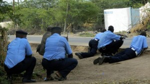 Kenyan police officers take cover outside the Garissa University College during an attack by gunmen in Garissa, Kenya, Thursday, April 2, 2015. Gunmen attacked the university early Thursday, shooting indiscriminately in campus hostels. Police and military surrounded the buildings and were trying to secure the area in eastern Kenya, police officer Musa Yego said. (AP Photo) 