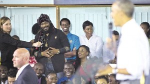 Miguel ‘Steppa’ Williams (left, standing) asks US President Barack Obama (right) a question about the legalisation of marijuana during a town hall meeting at the University of the West Indies in Kingston, yesterday. (PHOTO: AP)