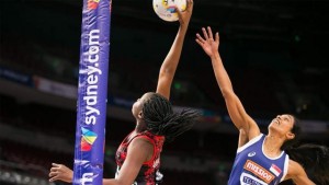 PROLIFIC: Samantha Wallace, left, leading overall scorer for the Calypso Girls at the Netball World Cup, reaches for a pass under the ring during T&T’s match yesterday against Singapore. She scored 27 goals as T&T romped to a 75-32 victory.