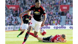 Manchester United's French striker Anthony Martial runs with the ball as Southampton's English defender Matt Targettlies is injured during their English Premier League match at St Mary's Stadium in Southampton, southern England, yesterday. Manchester won 3-2. 