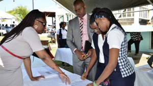 Minister Richards looks on as an exhibitor explains a process to students of CFBC