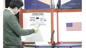 WORCESTER, USA — A voter examines a ballot at an early voting location yesterday in Worcester, Massachusetts. For the first time in Massachusetts, voters can cast their ballots for president before Election Day. Early voting will continue through November 4.